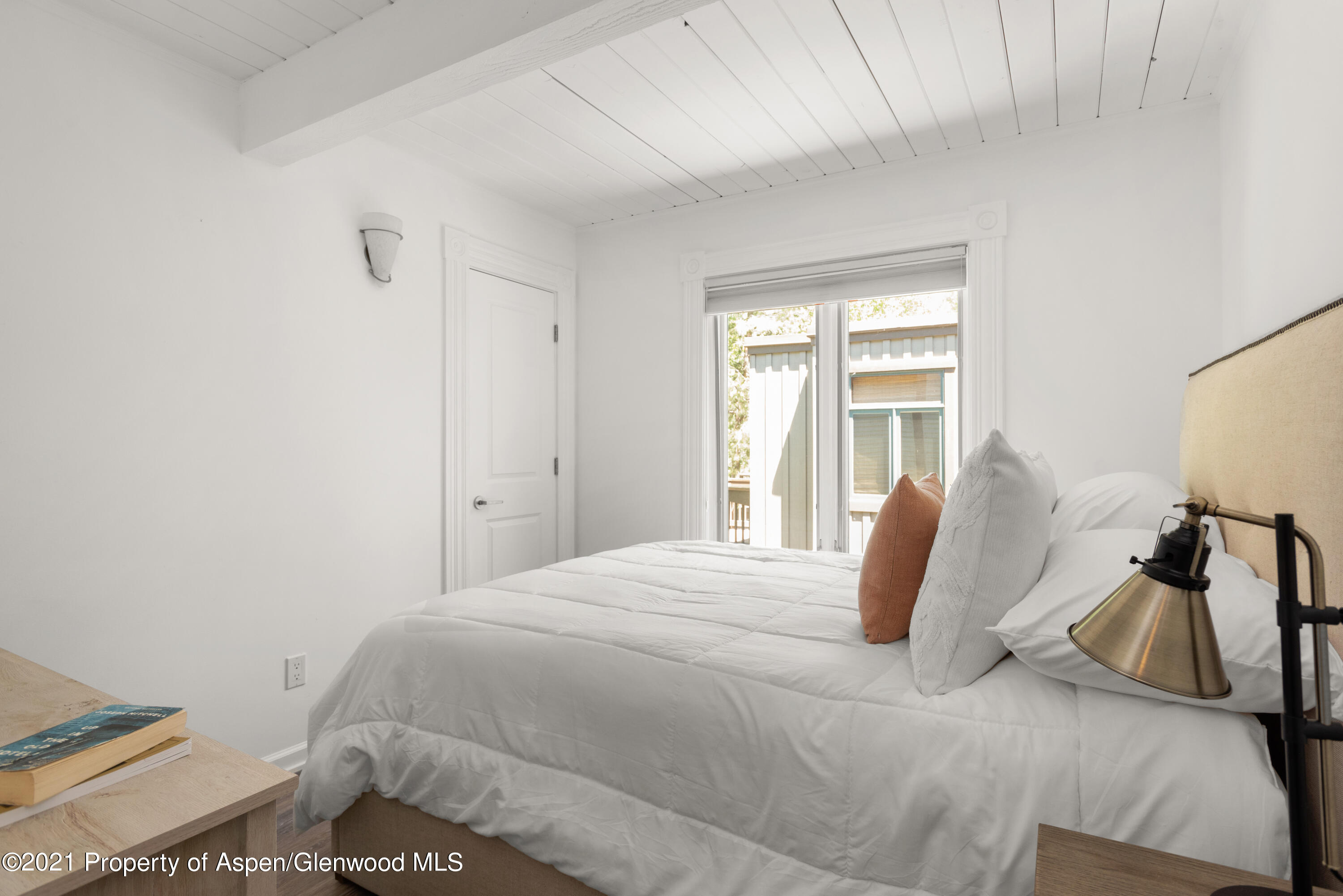 916 East Hopkins Avenue, Unit 204 Aspen, CO 81611 - Photo 8 of 14 a bedroom with a bed and wooden floor