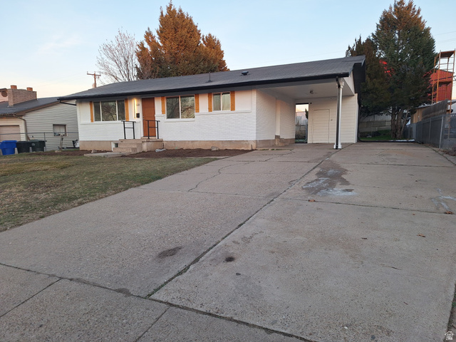 1226 North 450 West Sunset, UT 84015 - Photo 1 of 1 View of front of home featuring concrete driveway, an attached carport, a lawn, and brick siding