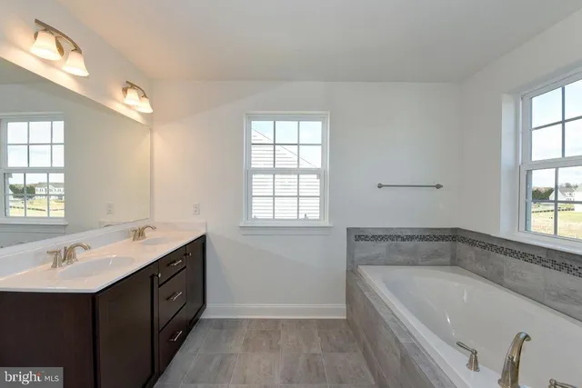 a bathroom with a tub a sink and mirror