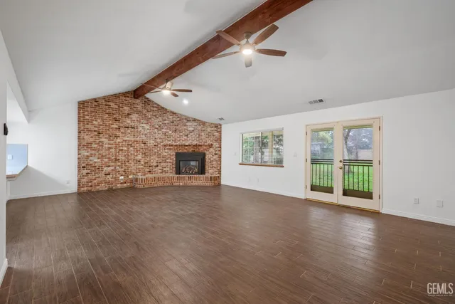 a living room with stainless steel appliances furniture a fireplace and a flat screen tv