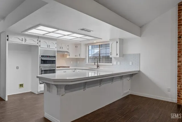 a kitchen with granite countertop a sink cabinets and window