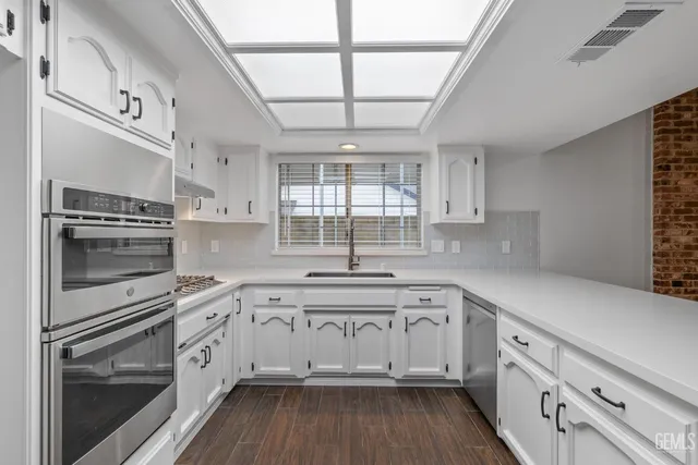 a kitchen with a sink cabinets and a window