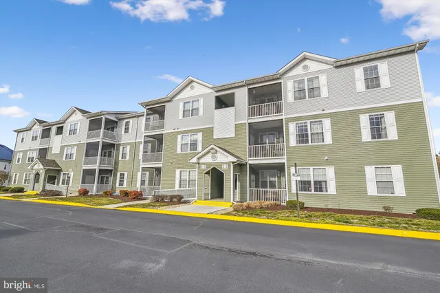 a view of a large pool with a lawn chairs under an umbrella