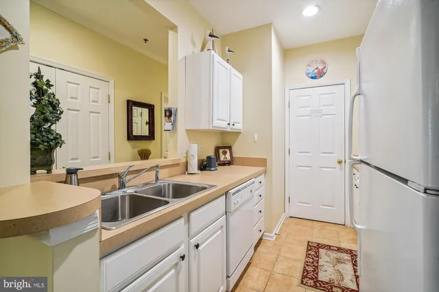 a kitchen with stainless steel appliances kitchen island granite countertop a sink and a refrigerator
