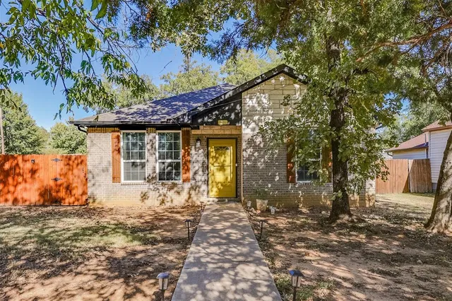 a front view of a house with a yard and tree