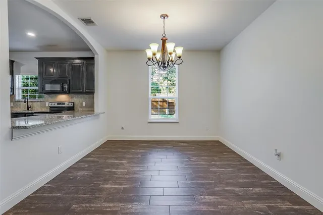 an empty room with chandelier and windows