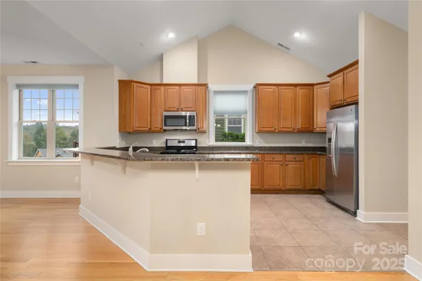 a kitchen with stainless steel appliances a refrigerator sink and microwave