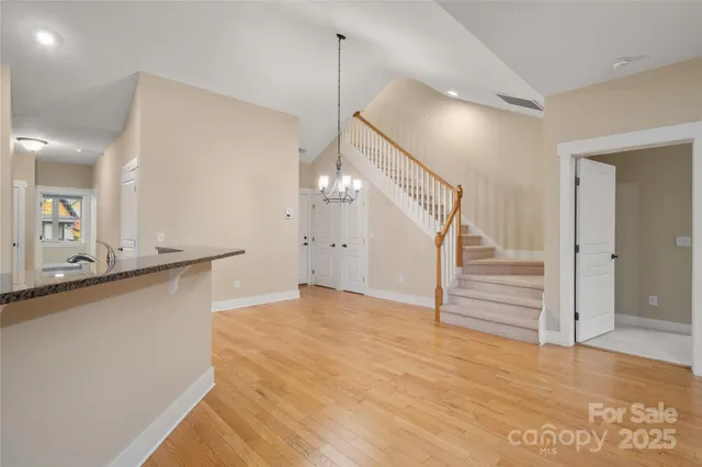 a view of a livingroom with wooden floor and staircase