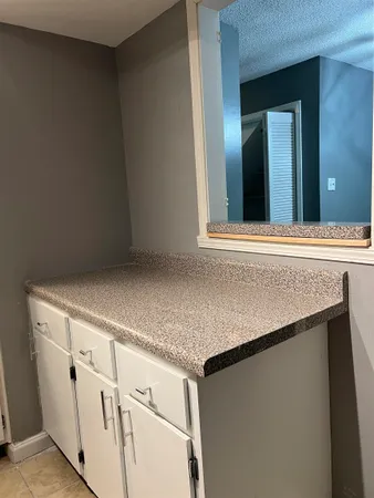 a view of a kitchen with white cabinets