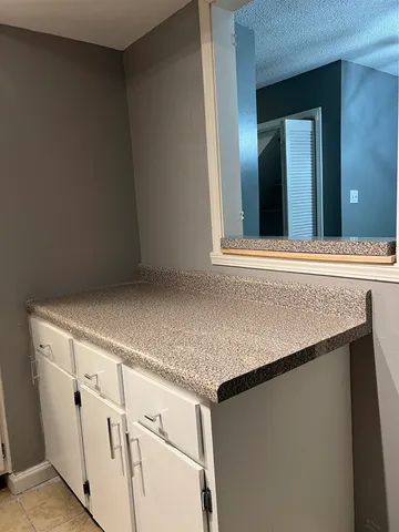 a view of a kitchen with white cabinets