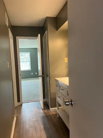 an empty room with wooden floor and mirror