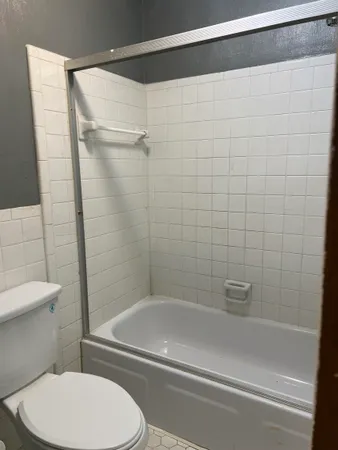 a view of an empty room with window and closet area