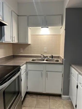 a kitchen with granite countertop white cabinets and white appliances