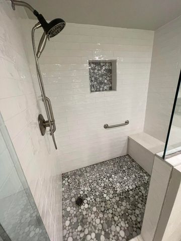 a large white bathroom with a granite countertop sink a toilet a mirror and shower