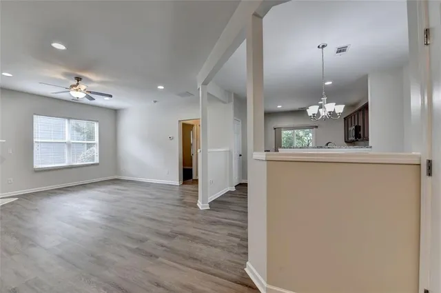 a view of a living room a hallway with wooden floor and a chandelier