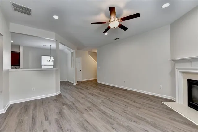 a view of empty room with wooden floor and ceiling fan
