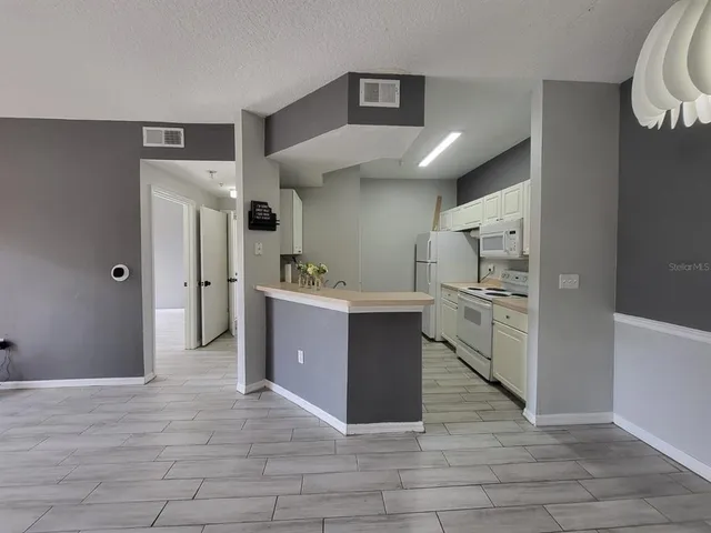 a view of a kitchen with refrigerator and cabinets