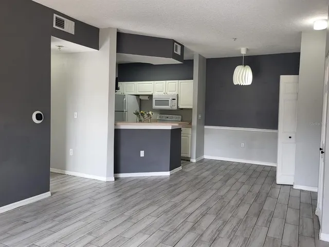 a view of kitchen with wooden floor and cabinets
