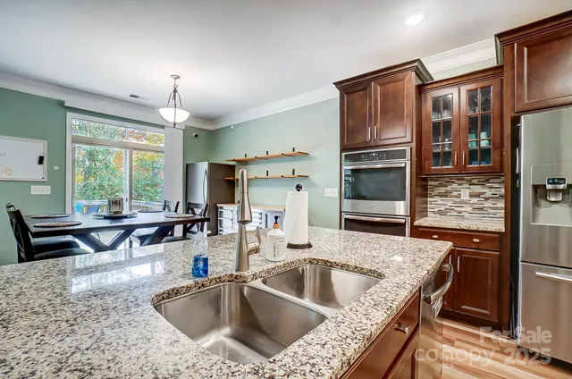 a kitchen with granite countertop a sink refrigerator and outdoor seating