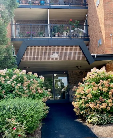 a front view of a house with a yard and garden