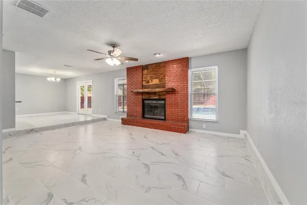 a view of an empty room with a fireplace and a window