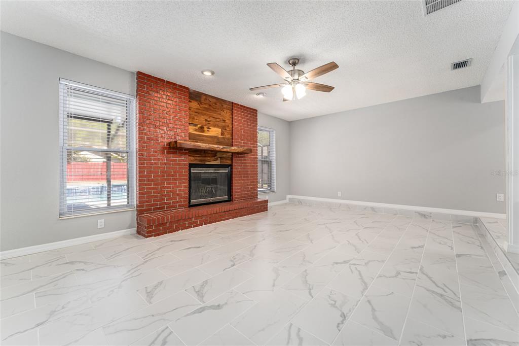 5041 Northeast 4th Street Ocala, FL 34470 - Photo 14 of 70 a view of an empty room with a fireplace and a window
