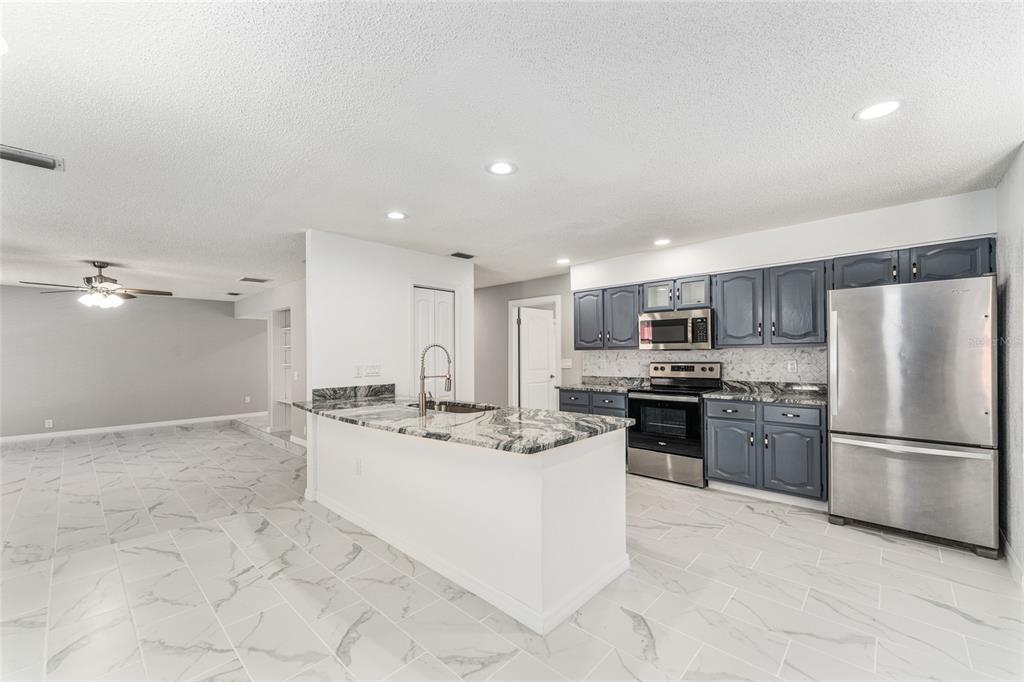 5041 Northeast 4th Street Ocala, FL 34470 - Photo 22 of 70 a kitchen with stainless steel appliances granite countertop a refrigerator sink and stove