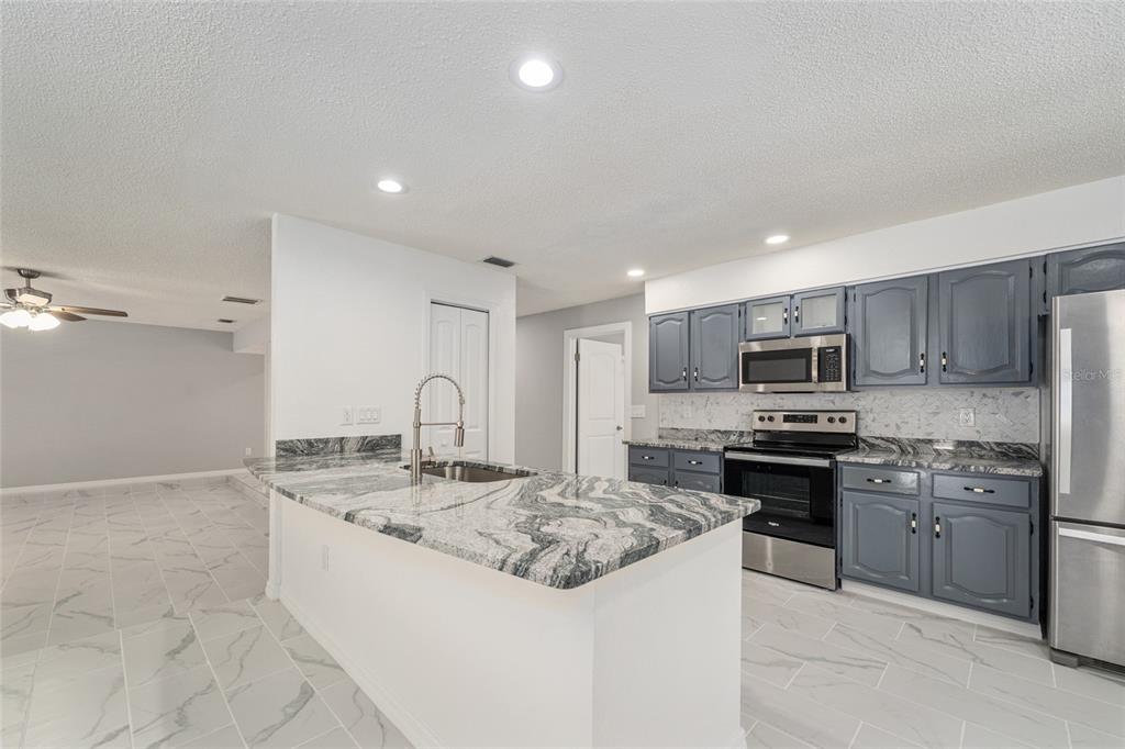 5041 Northeast 4th Street Ocala, FL 34470 - Photo 24 of 70 a kitchen with stainless steel appliances granite countertop a sink and a stove