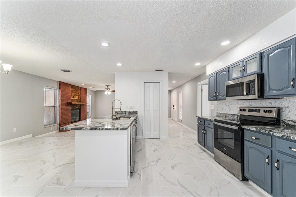 5041 Northeast 4th Street Ocala, FL 34470 - Photo 26 of 70 a kitchen with stainless steel appliances kitchen island granite countertop a stove and a sink