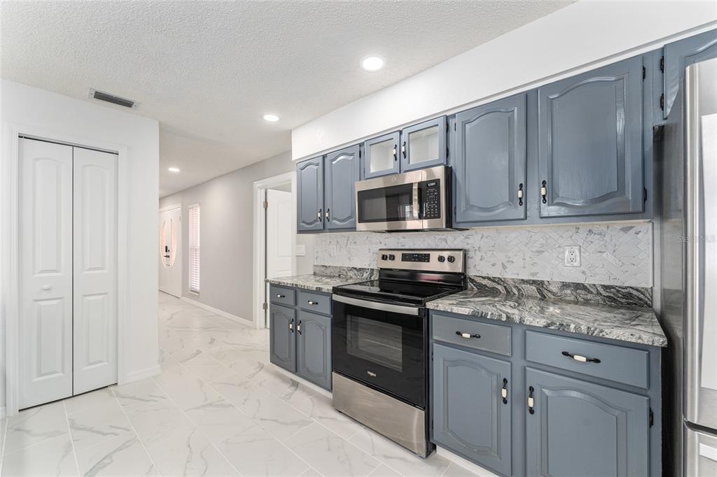 5041 Northeast 4th Street Ocala, FL 34470 - Photo 27 of 70 a kitchen with stainless steel appliances granite countertop a stove a sink and a microwave