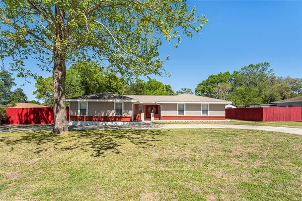 a front view of house with yard and trees in the background
