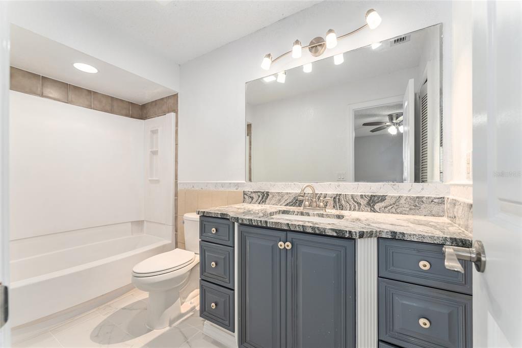 5041 Northeast 4th Street Ocala, FL 34470 - Photo 40 of 70 a bathroom with a granite countertop sink toilet and shower