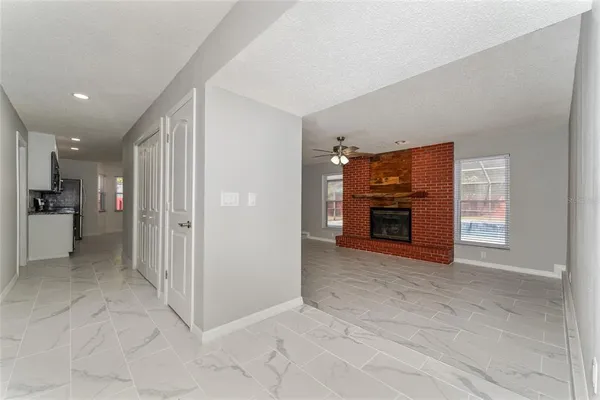 a view of an empty room with a fireplace and a window
