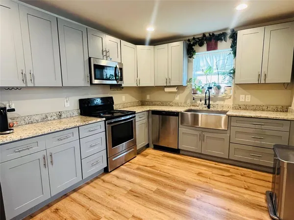a kitchen with white cabinets stainless steel appliances and sink