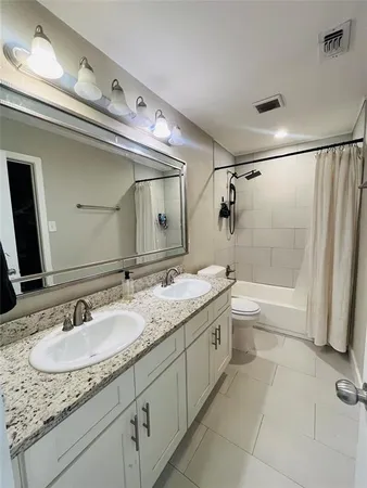 a bathroom with a granite countertop sink a toilet and a mirror