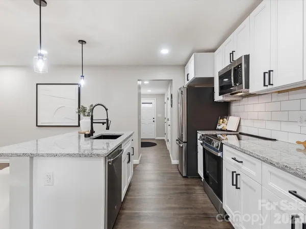 a kitchen with stainless steel appliances granite countertop a sink stove and refrigerator