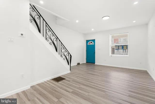 a view of large kitchen with stainless steel appliances kitchen island granite countertop a refrigerator a stove and a sink with wooden floor