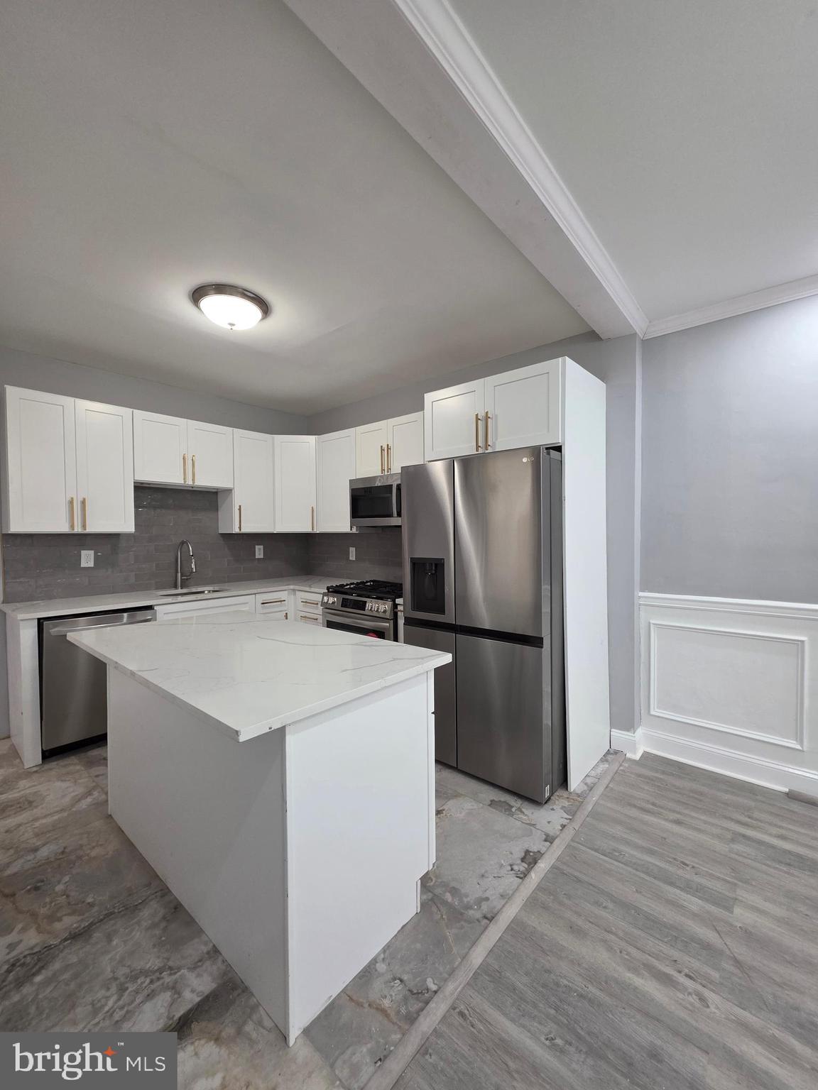 6026 Irving Street Philadelphia, PA 19139 - Photo 11 of 30 a kitchen with stainless steel appliances a refrigerator stove microwave and cabinets