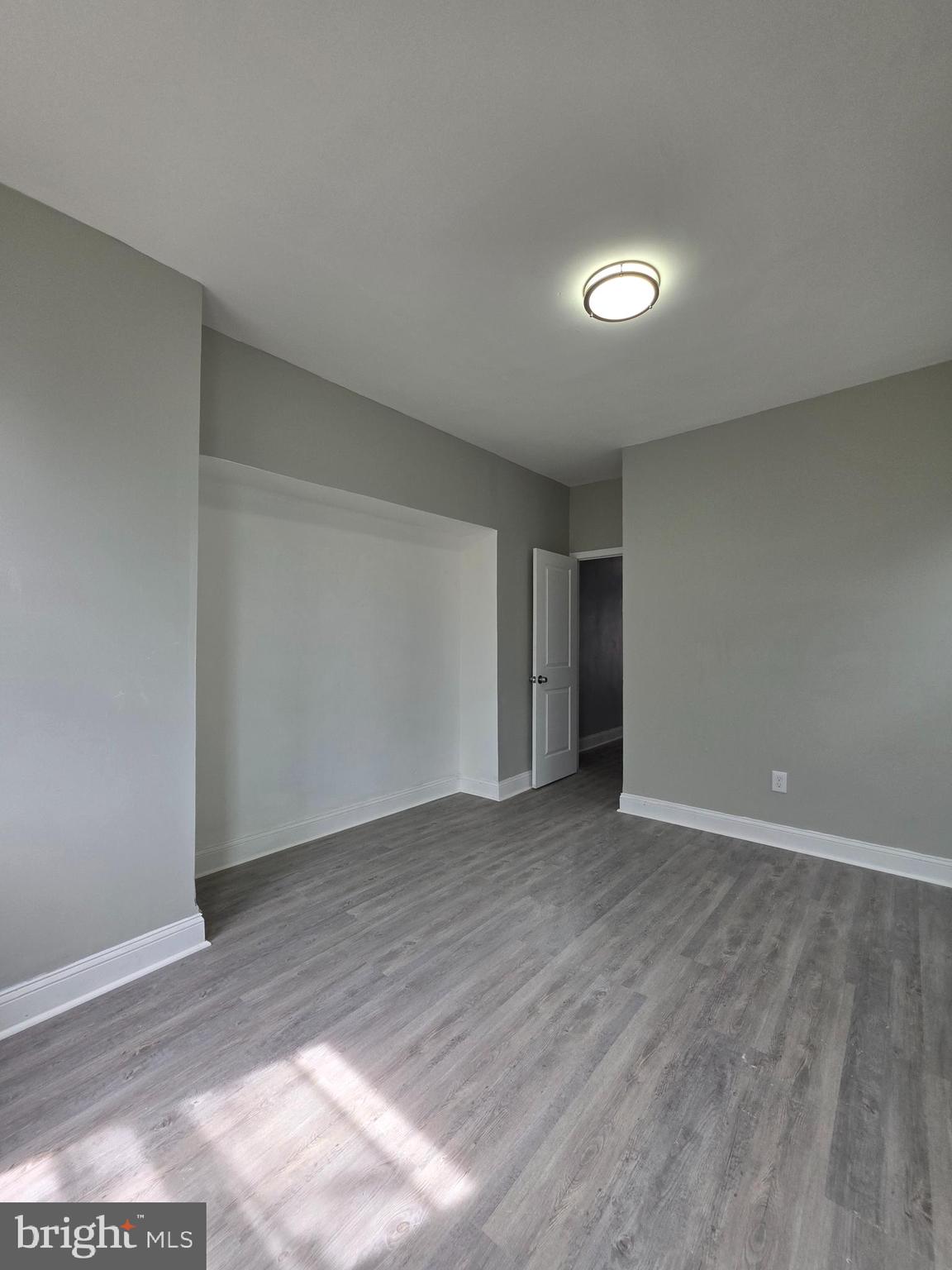 6026 Irving Street Philadelphia, PA 19139 - Photo 20 of 30 a view of an empty room with wooden floor and a window