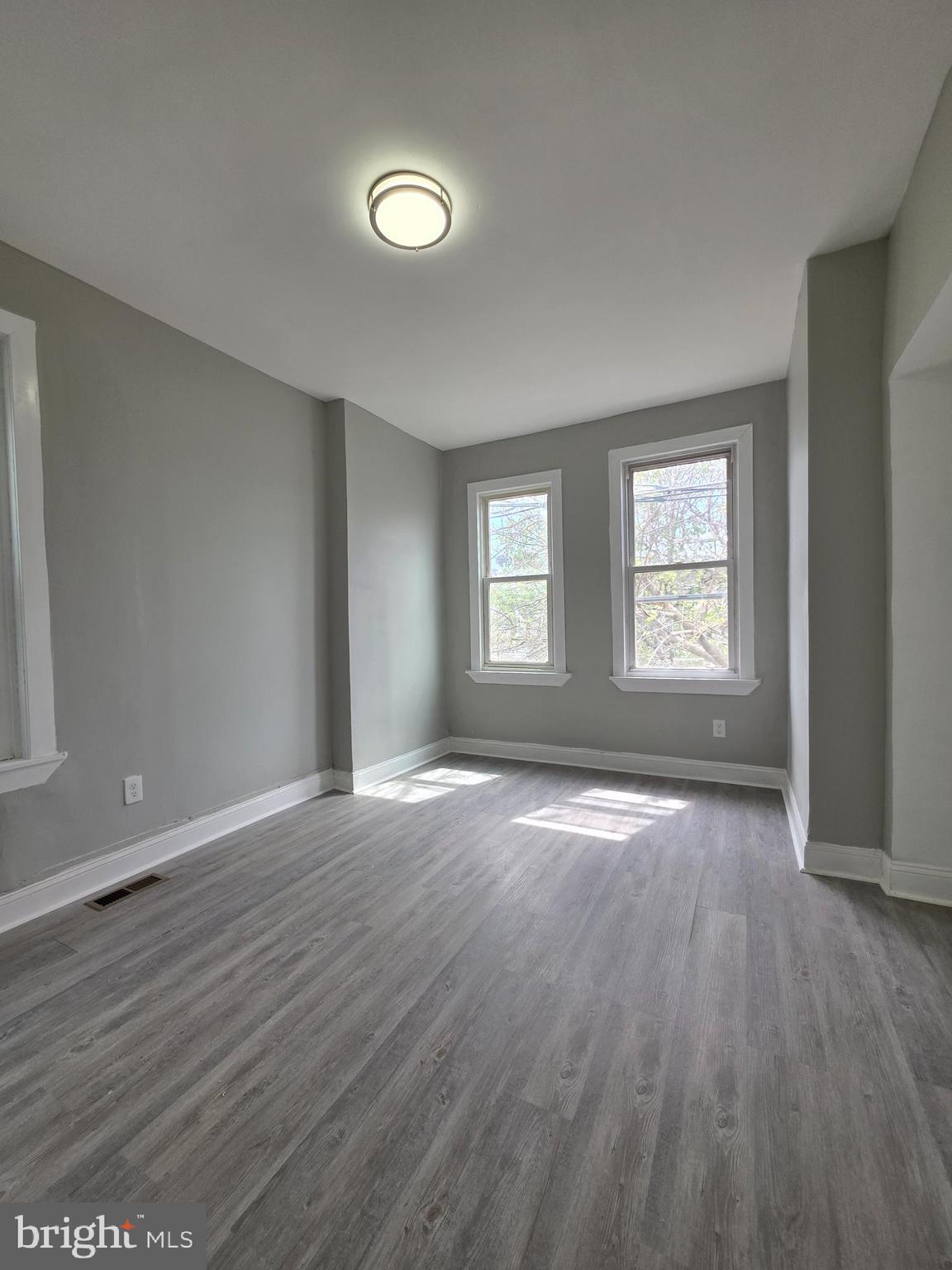 6026 Irving Street Philadelphia, PA 19139 - Photo 22 of 30 an empty room with wooden floor and windows
