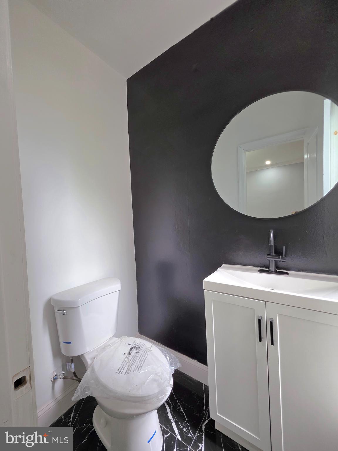 6026 Irving Street Philadelphia, PA 19139 - Photo 7 of 30 a bathroom with a toilet sink and mirror