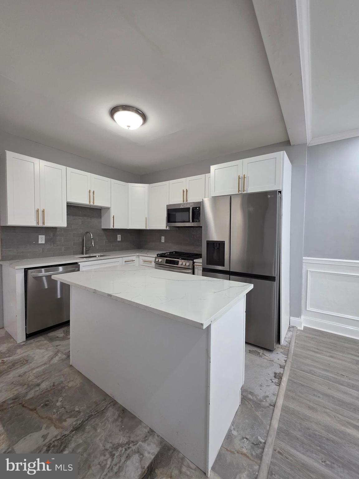 6026 Irving Street Philadelphia, PA 19139 - Photo 10 of 30 a large kitchen with stainless steel appliances a refrigerator a stove a sink dishwasher a oven with white cabinets and wooden floor