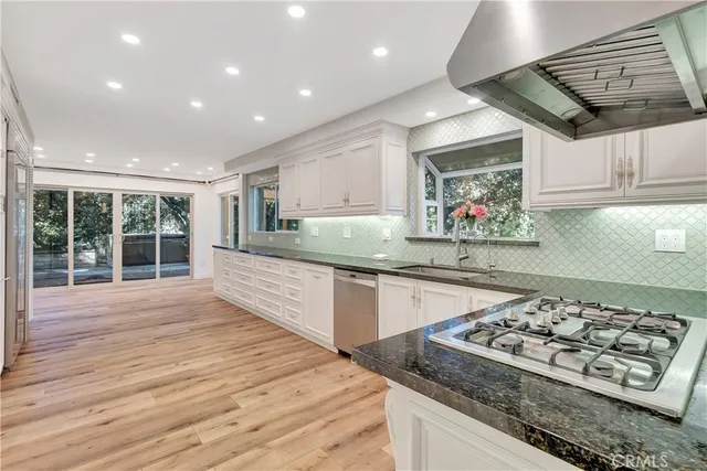 a kitchen with stainless steel appliances granite countertop a stove and a wooden cabinets