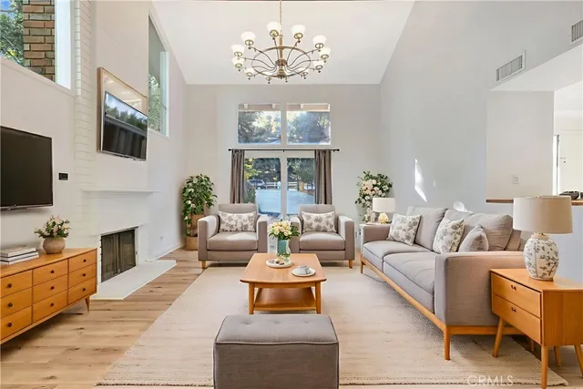 a living room with furniture a chandelier and a flat screen tv