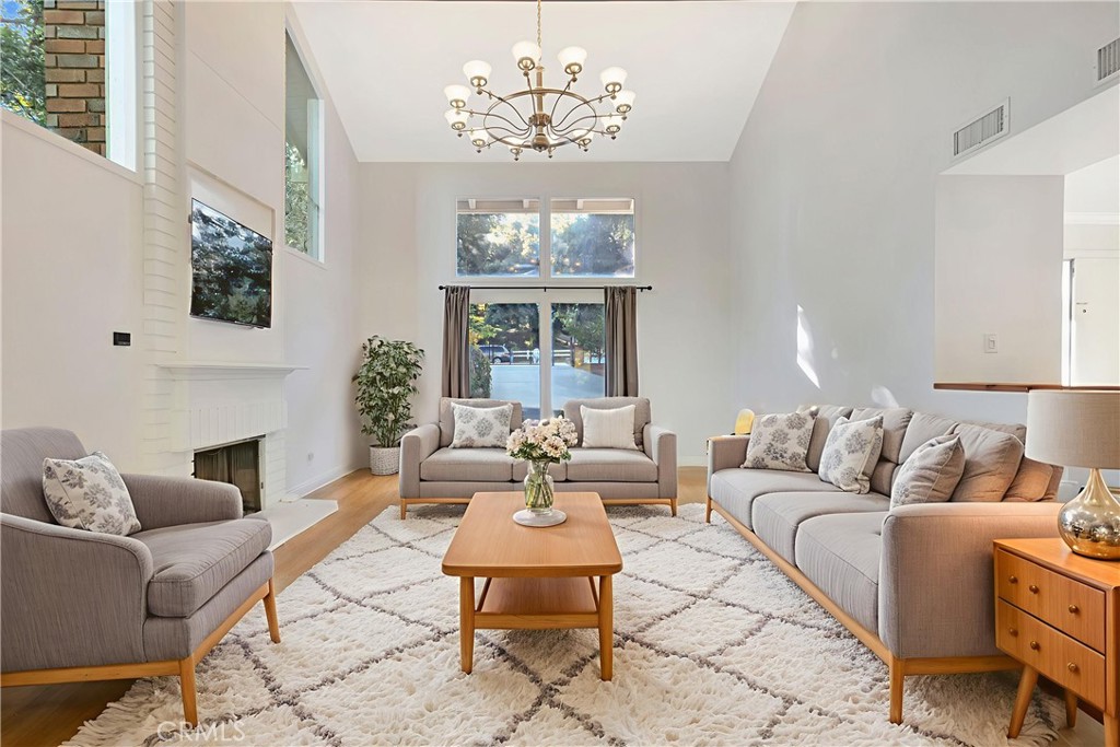 119 Bell Cyn Road Bell Canyon, CA 91307 - Photo 7 of 18 a living room with furniture chandelier and a fireplace