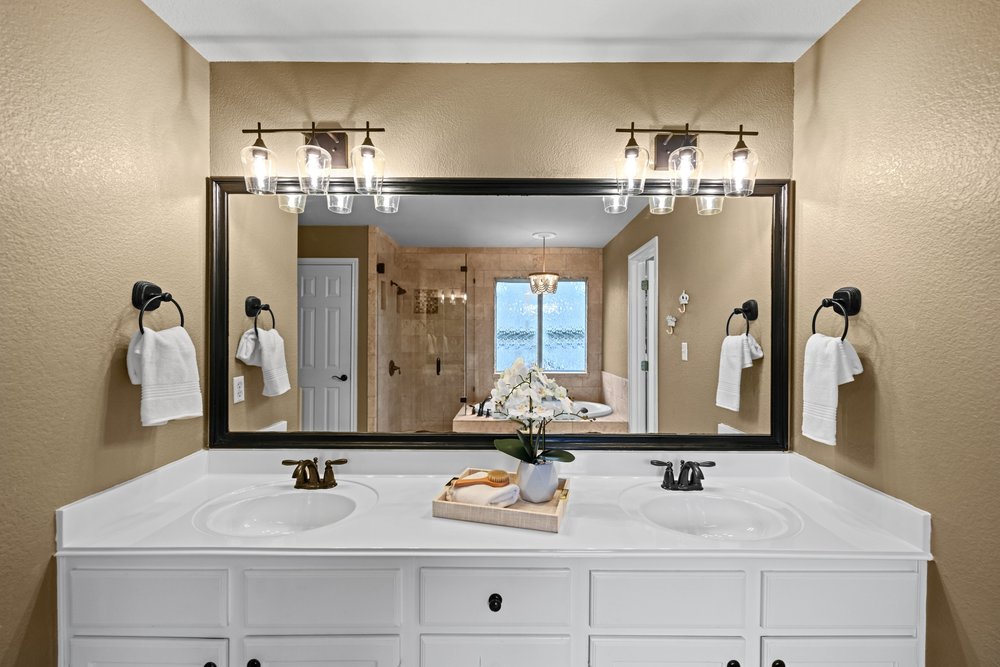 2823 Lantana Ridge Drive Austin, TX 78732 - Photo 20 of 34 a bathroom with double vanity sinks a vanity and a mirror