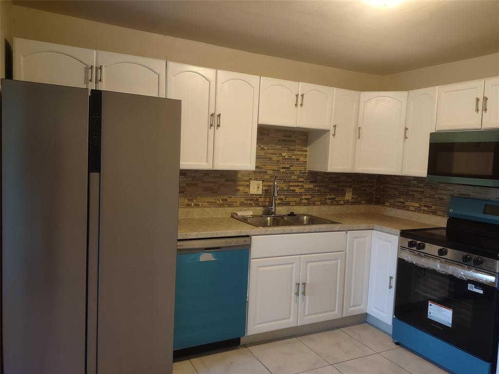 128 Miami Gardens Road West Park, FL 33023 - Photo 11 of 38 a kitchen with stainless steel appliances white cabinets and a refrigerator