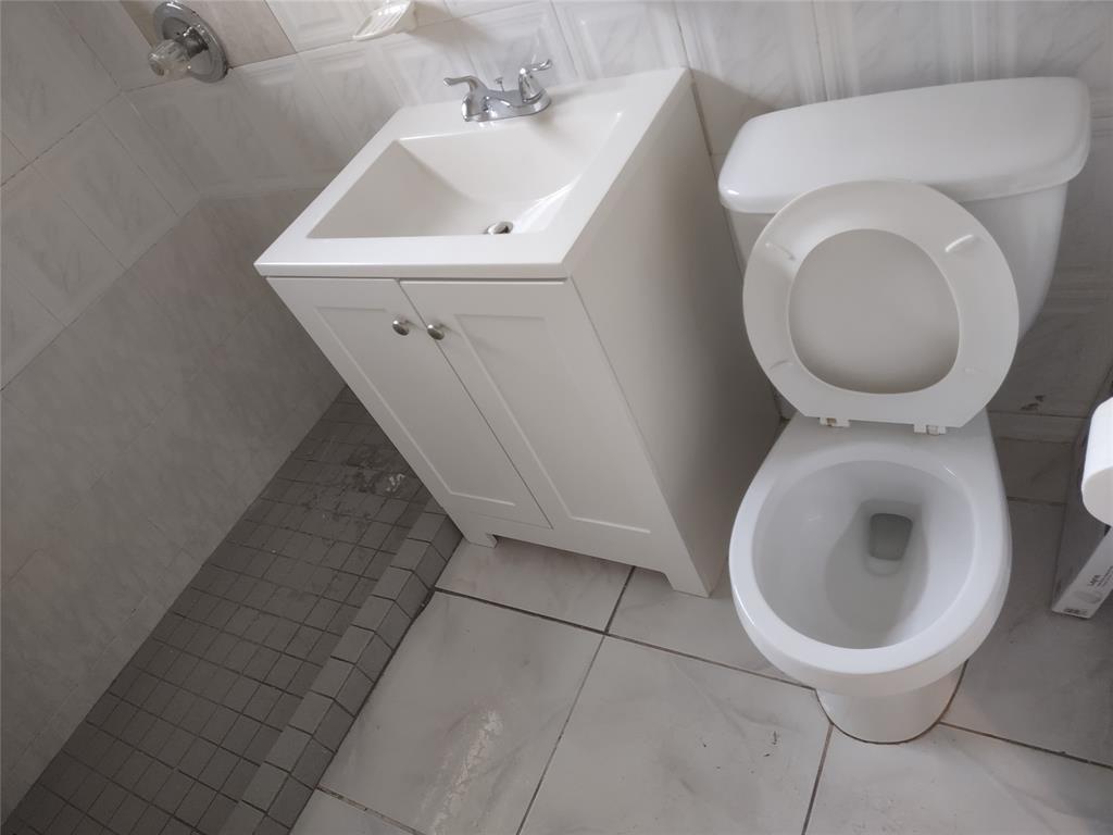 128 Miami Gardens Road West Park, FL 33023 - Photo 20 of 38 a bathroom with a toilet sink and mirror