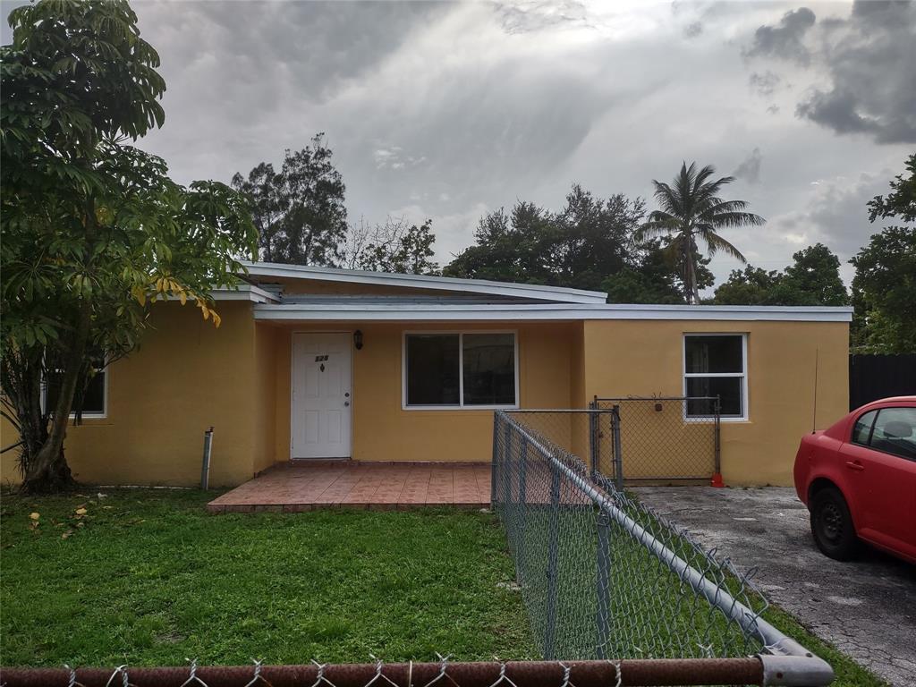 128 Miami Gardens Road West Park, FL 33023 - Photo 4 of 38 a view of a backyard with couches plants and large trees