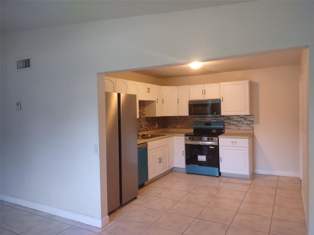128 Miami Gardens Road West Park, FL 33023 - Photo 7 of 38 a kitchen with stainless steel appliances granite countertop a refrigerator and a stove top oven